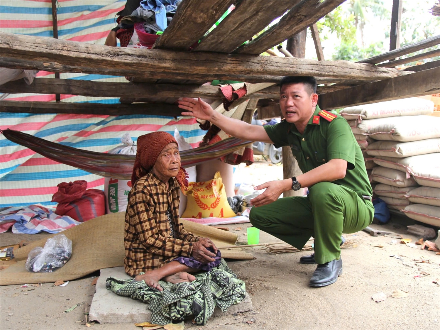 Thiếu tá Lê Đình Hải, Phó Trưởng Công an xã Ia Pa ủng hộ kinh phí hỗ trợ xây nhà ở cho bà H’Quế, 75 tuổi, người Gia Rai ở xã Ia Pa, tỉnh Gia Lai - Ảnh Ngọc Thu