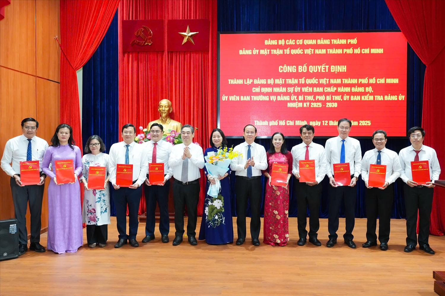 Ông Lưu Phước Lộc (thứ 6 từ trái sang) Phó bí thư Thành uỷ, Chủ tịch UBMTTQ Việt Nam TP.HCM và ông Nguyễn Khoa Hải (thứ 8 từ trái sang) Phó bí` thư Đảng uỷ các cơ quan Đảng TP.HCM trao quyết định và tặng hoa chúc mừng Ban Chấp hành Đảng bộ UB MTTQ Việt Nam TP. HCM