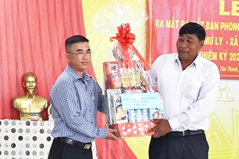 Phó Chủ tịch UBND xã Tân Thành (bên trái) tặng quà cho Trưởng Ban phong tục tại buổi Lễ ra mắt