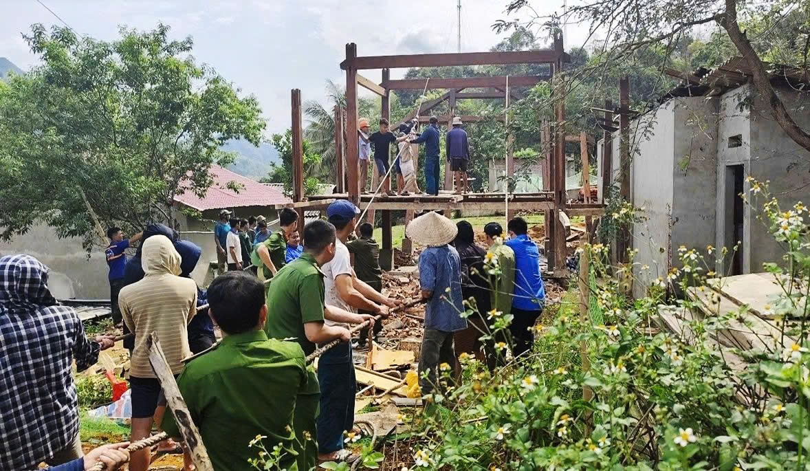 Công an xã Na Mèo giúp người dân tháo dỡ nhà cũ. Ảnh: Quỳnh Trâm