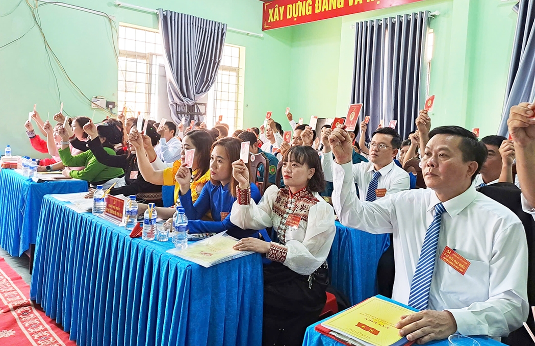 Các đại biểu biểu quyết các chỉ tiêu của Nghị quyết. (Ảnh: Lê Hường)