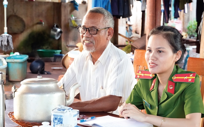 Thượng úy Thị Kim Phượng cùng với già làng, Người có uy tín Điểu PLô đến nhà đồng bào Xtiêng để tuyên truyền, phổ biến pháp luật và đăng ký định danh điện tử.