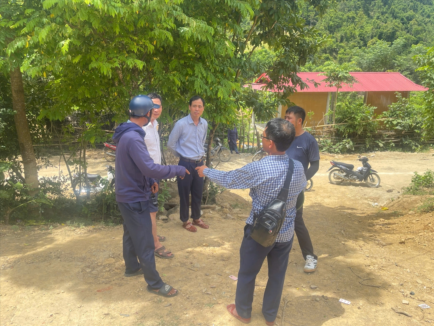 Ban chỉ đạo Chương trình xóa nhà tạm, nhà dột nát xã Môn Sơn trao đổi với Ban quản lý bản và đơn vị thi công về tiến độ xây dựng nhà cho người dân Đan Lai - Ảnh: TH 