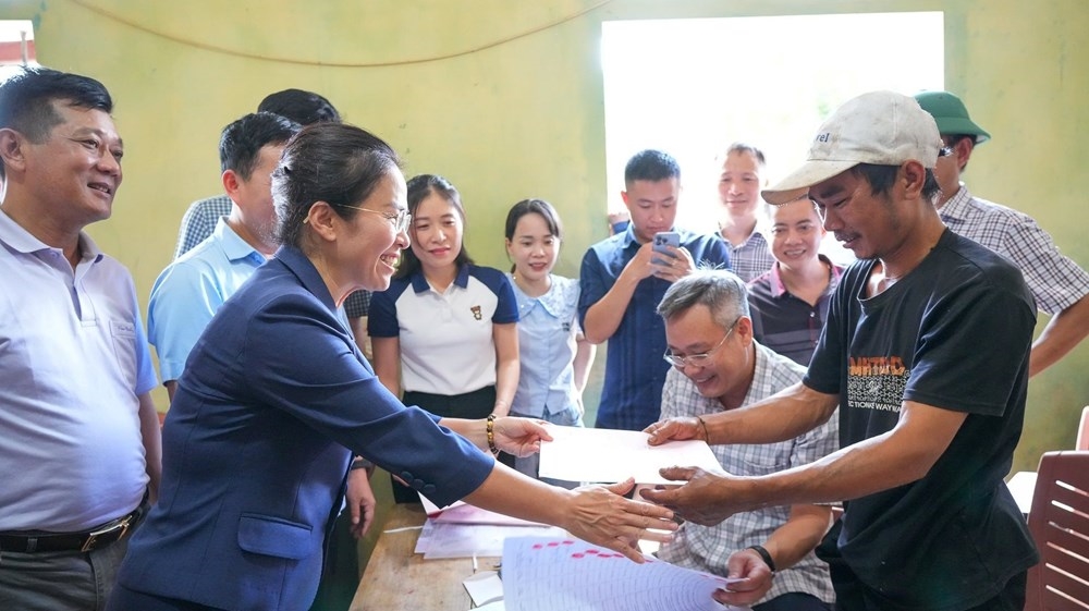 Niềm vui của người dân khi chính thức được Nhà nước chứng nhận là chủ sở hữu của mảnh đất xây nhà và ruộng vườn của gia đình - Ảnh: TC