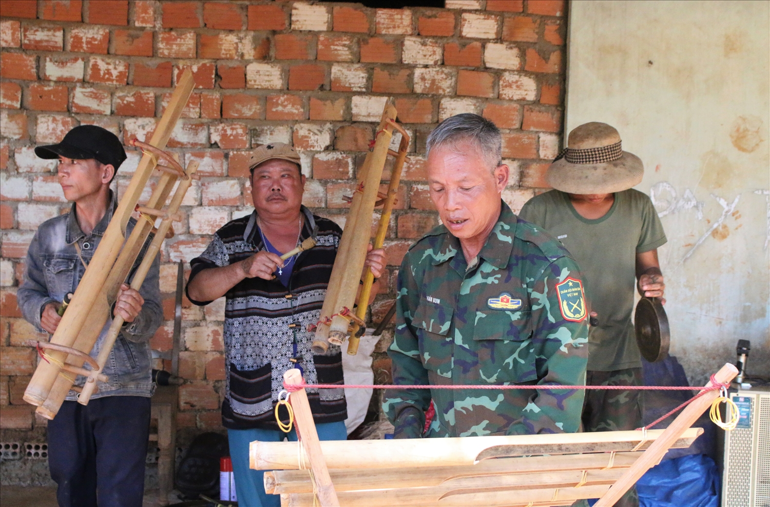 Ông A Bay (đánh đàn Tơ rưng), làng Đăk Rô Gia say xưa tập cùng các nghệ nhân làng Đăk Rô Gia. (Ảnh: Ngọc Chí)