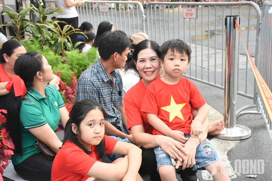 Cháu Trần Minh Đức, 6 tuổi, quê Hưng Yên, cùng gia đình gồm 5 người đi từ Hưng Yên đến khu vực trước cửa Nhà Hát lớn từ 12 giờ trưa, chờ xem tổng hợp luyện diễu binh, diễu hành (Ảnh: Báo QĐND).