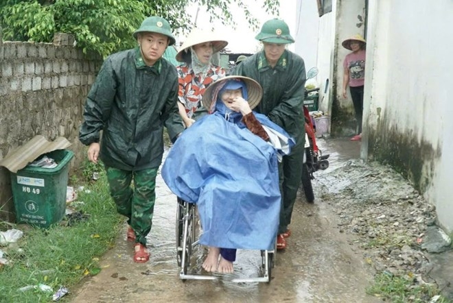 Cơ quan chức năng địa phương hỗ trợ di dời người dân đến nơi tránh trú bão an toàn.(ảnh PV)