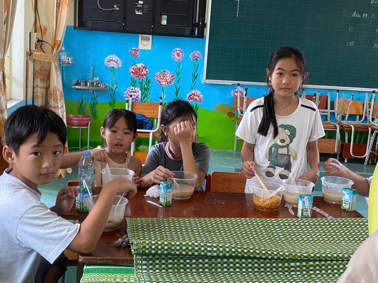 Cháu Ngũ Nguyễn Gia Long (bìa trái) – lớp 4, xóm Chiến Thắng cho biết: Năm ngoái cháu học lớp này, bây giờ tránh bão lại vào đây, thích quá. Các bạn cháu đều vui, đợi bão hết thì sẽ về nhà chuẩn bị đi học. - Ảnh: Thanh Hải