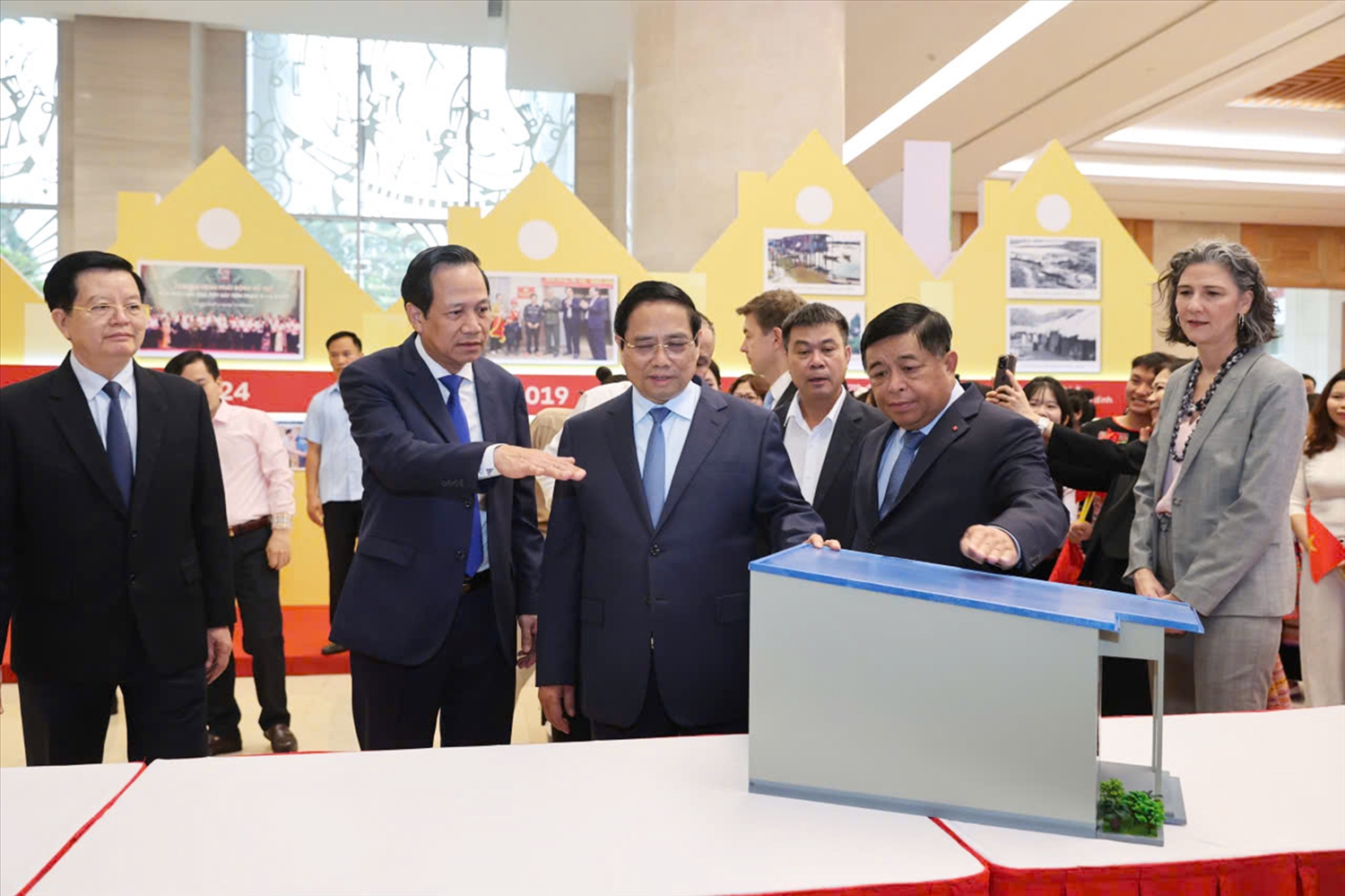 Bộ trưởng Đào Ngọc Dung giới thiệu với Thủ tướng và các đại biểu một số mô hình nhà đã được xây dựng