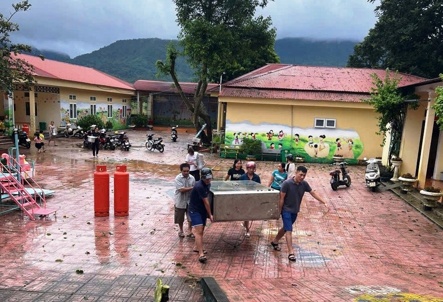 Người dân cùng chung tay di chuyển đồ cho Trường Mầm non Thiết Ống.(ảnh PV)