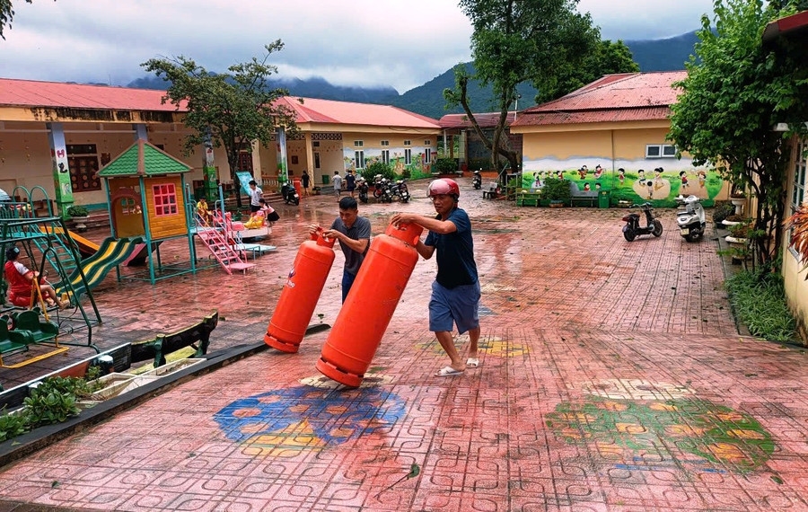 Người dân cùng chung tay di chuyển đồ cho Trường Mầm non Thiết Ống.(ảnh PV)