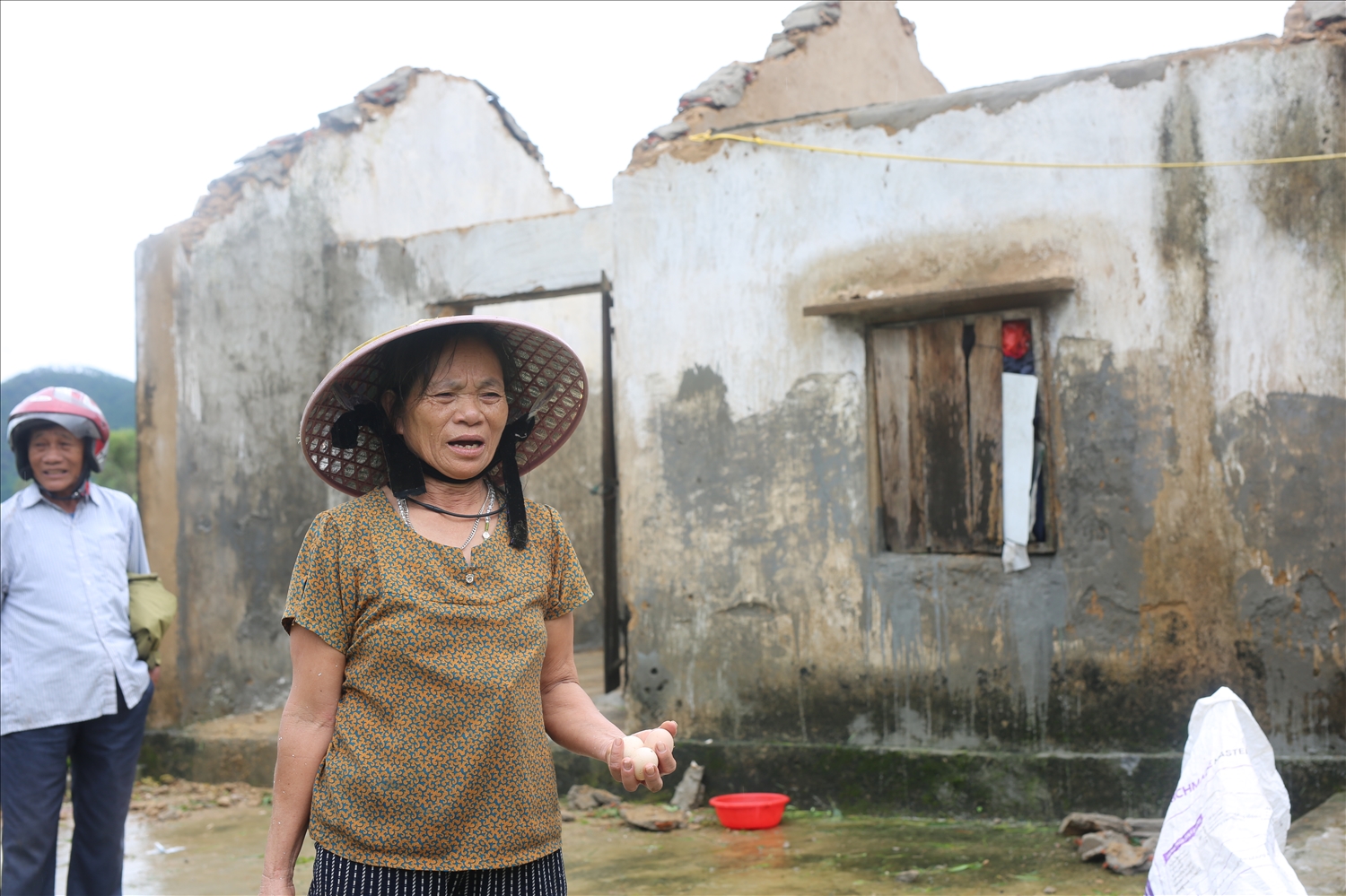 Bà Nguyễn Thị Thành, ở xóm 5, xã Trung Lộc trước căn nhà toang hoác do bão số 5 gây ra - Ảnh: Thanh Hải