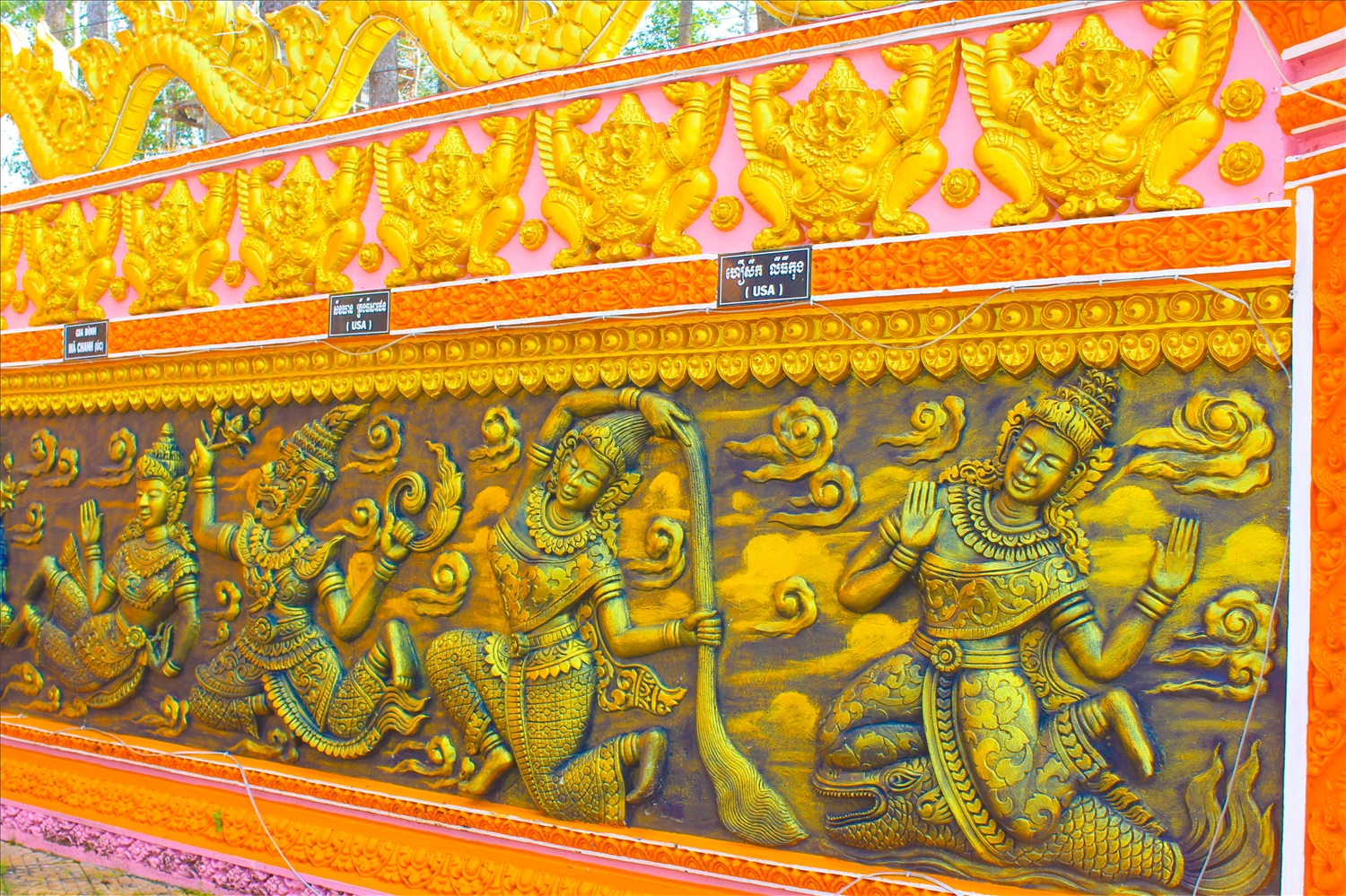 Bức tường trước cổng chùa với những họa tiết, hình ảnh được đắp nổi đẹp mắt.