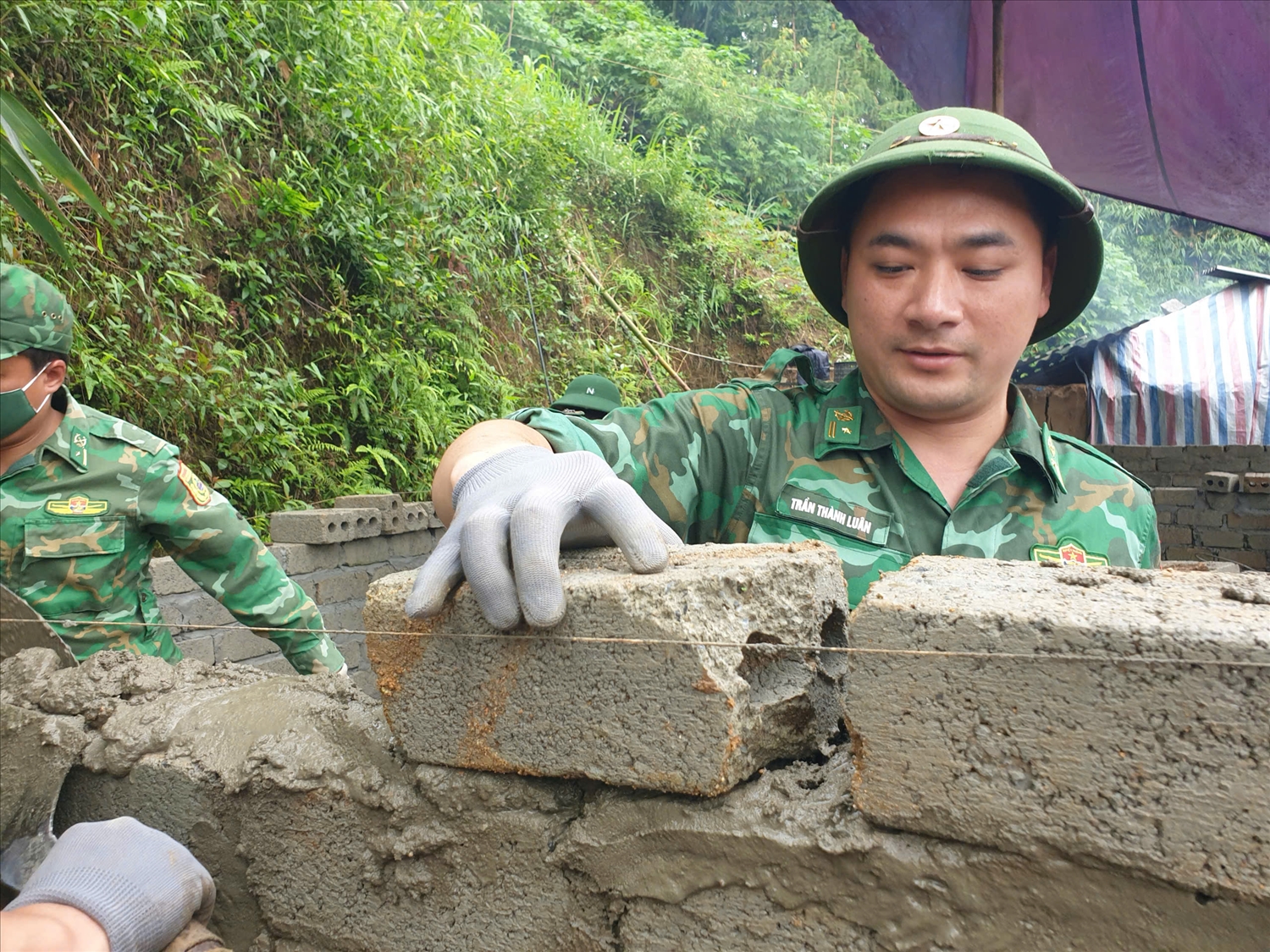 Cán bộ chiến sĩ Đồn Biên phòng Sì Lở Lầu giúp dân xây dựng nhà