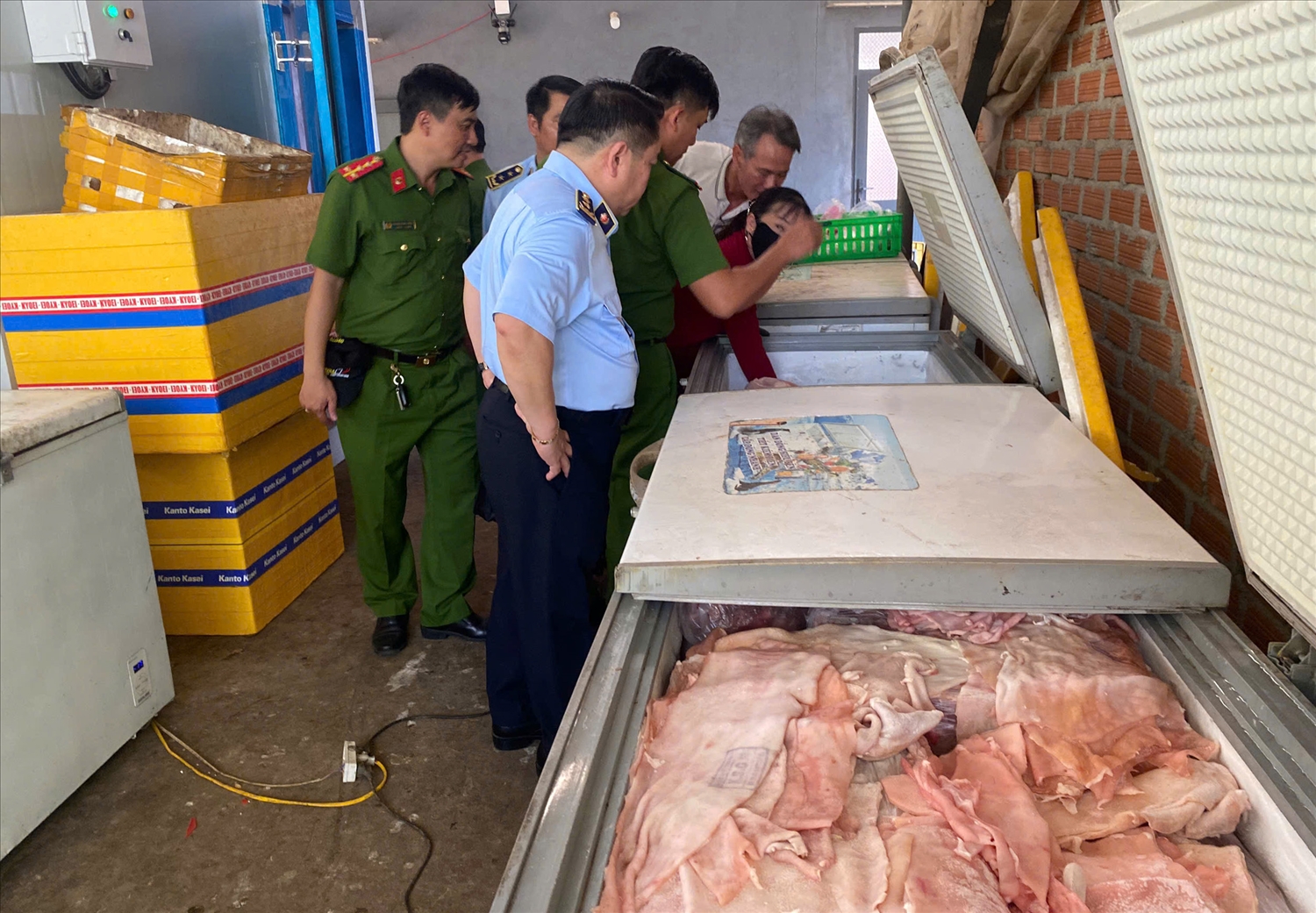 Lực lượng chức năng kiểm tra số thịt heo ở các tủ đông nhà bà Ng.T.T (Ảnh QLTT)