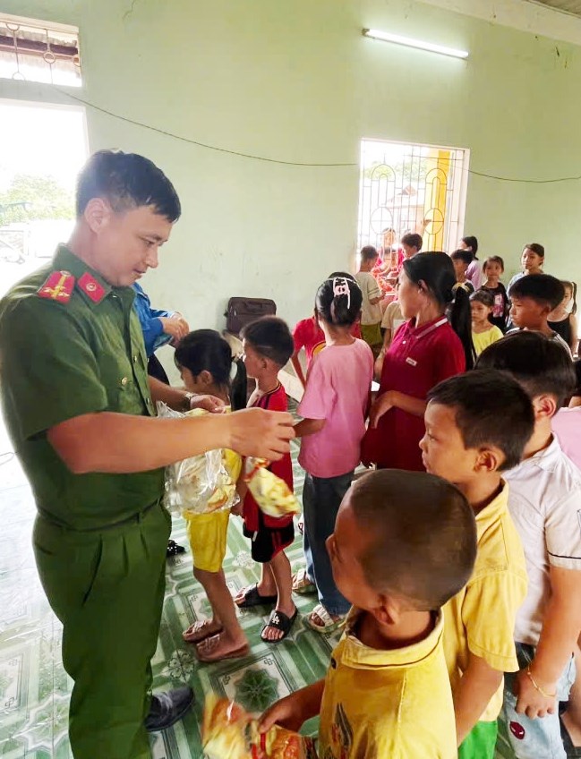 Thượng úy Lý Văn Hòa phát kẹo cho các cháu Trường Mầm non xã Tân Mỹ nhân dịp Ngày Quốc tế Thiếu nhi 1/6/2025