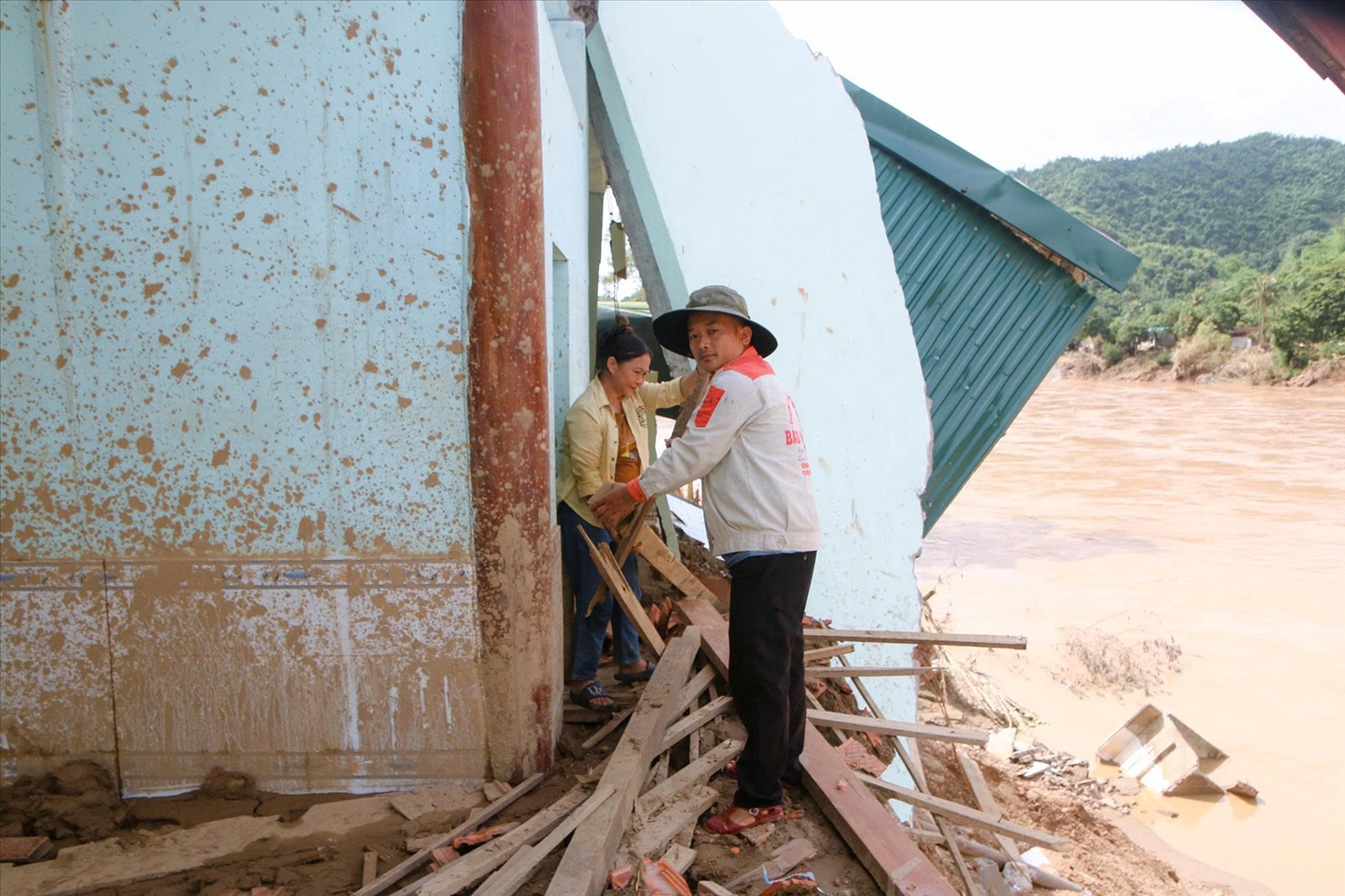 Ngay sau khi nước rút, Trưởng bản Lô Xuân Thủy đến hỗ trợ các gia đình bị sập nhà khắc phục hậu quả sau mưa lũ (Ảnh: Đình Tuân)