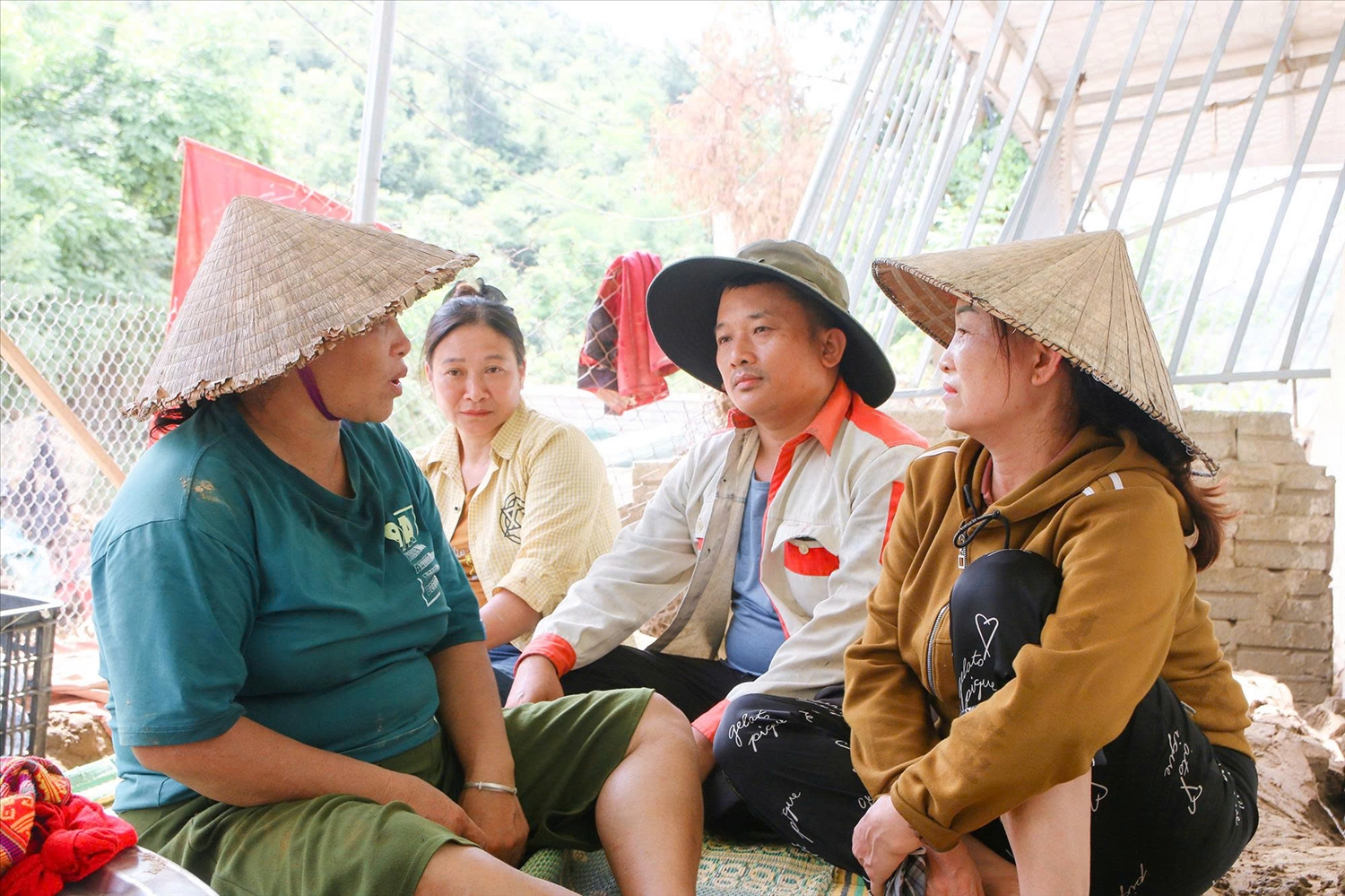 Anh Thủy và bà con dân tộc Thái ở Thạch Dương động viên nhau sau mưa lũ (Ảnh: Đình Tuân)