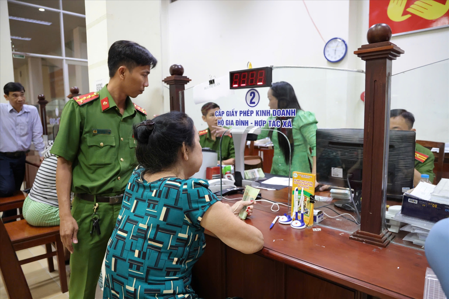 Các cán bộ làm nhiệm vụ giúp đỡ bà con nhận quà Quốc khánh. (Ảnh: Trung Phạm)