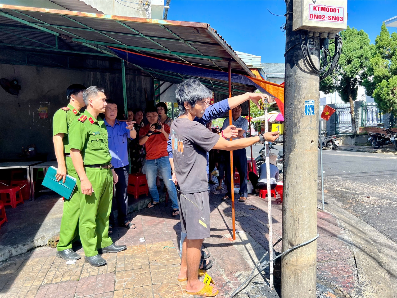 Công an phường Kon Tum dựng lại hiện trường điều tra vụ việc đốt trụ điện. (Ảnh: Công ty Điện lực Quảng Ngãi)