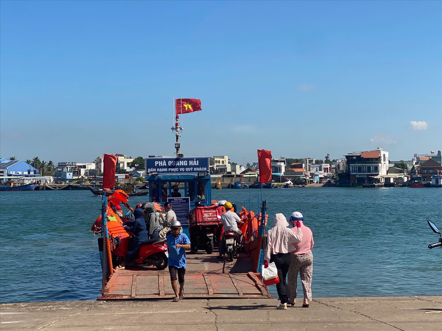 Trong khi phà sắt chờ sửa chữa, người dân phải qua lại bằng phà gỗ nhỏ. (Ảnh Huy Trường).