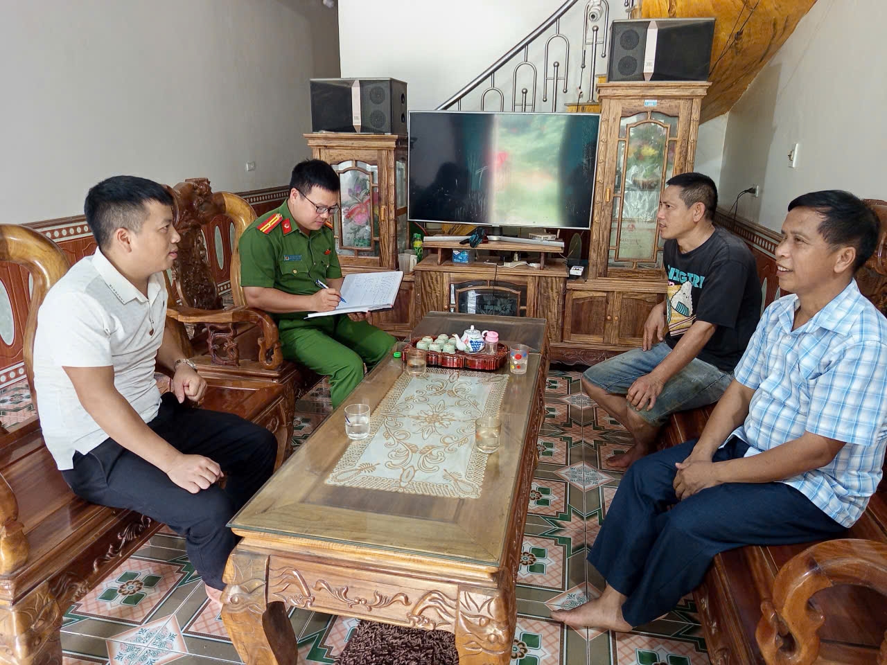 Trưởng thôn Vũ Văn Linh (người mặc áo trắng) cùng lực lượng Công an xã Thái Bình tuyên truyền, phổ biến pháp luật tại hộ gia đình trong thôn Cả 
