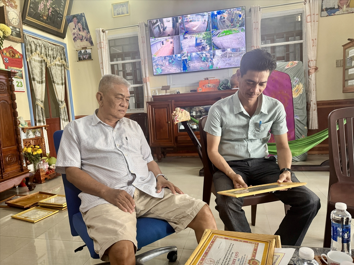Ông Ngô Văn Húa ( bìa trái) chia sẻ những kết quả được ghi nhận với anh Nguyễn Văn Xa - cán bộ phòng văn hoá, xã hội của phường Rạch Giá