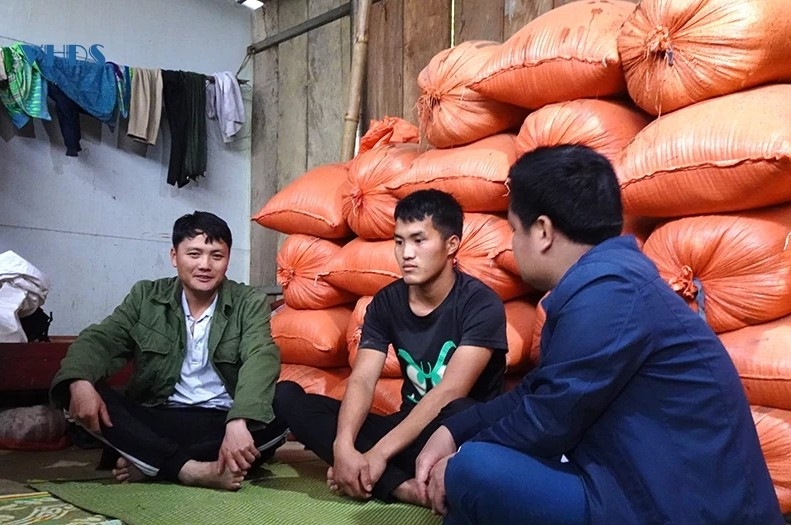 Anh Vàng A Sùng (ngoài cùng bên trái), Bí thư chi bộ bản Khằm 1, đến từng hộ dân để tuyên truyền xóa bỏ tảo hôn. Ảnh: Đình Giang