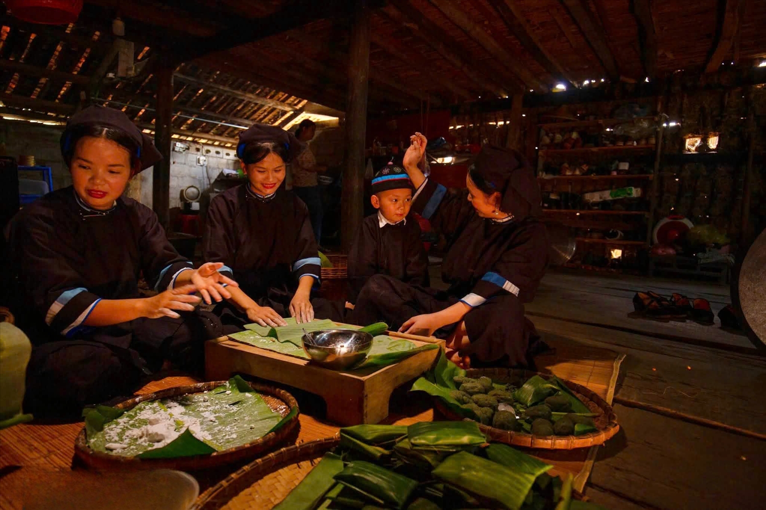 Những đôi tay thoăn thoắt gói bánh, buộc lạt; tiếng cười nói rộn ràng trong gian bếp sàn.