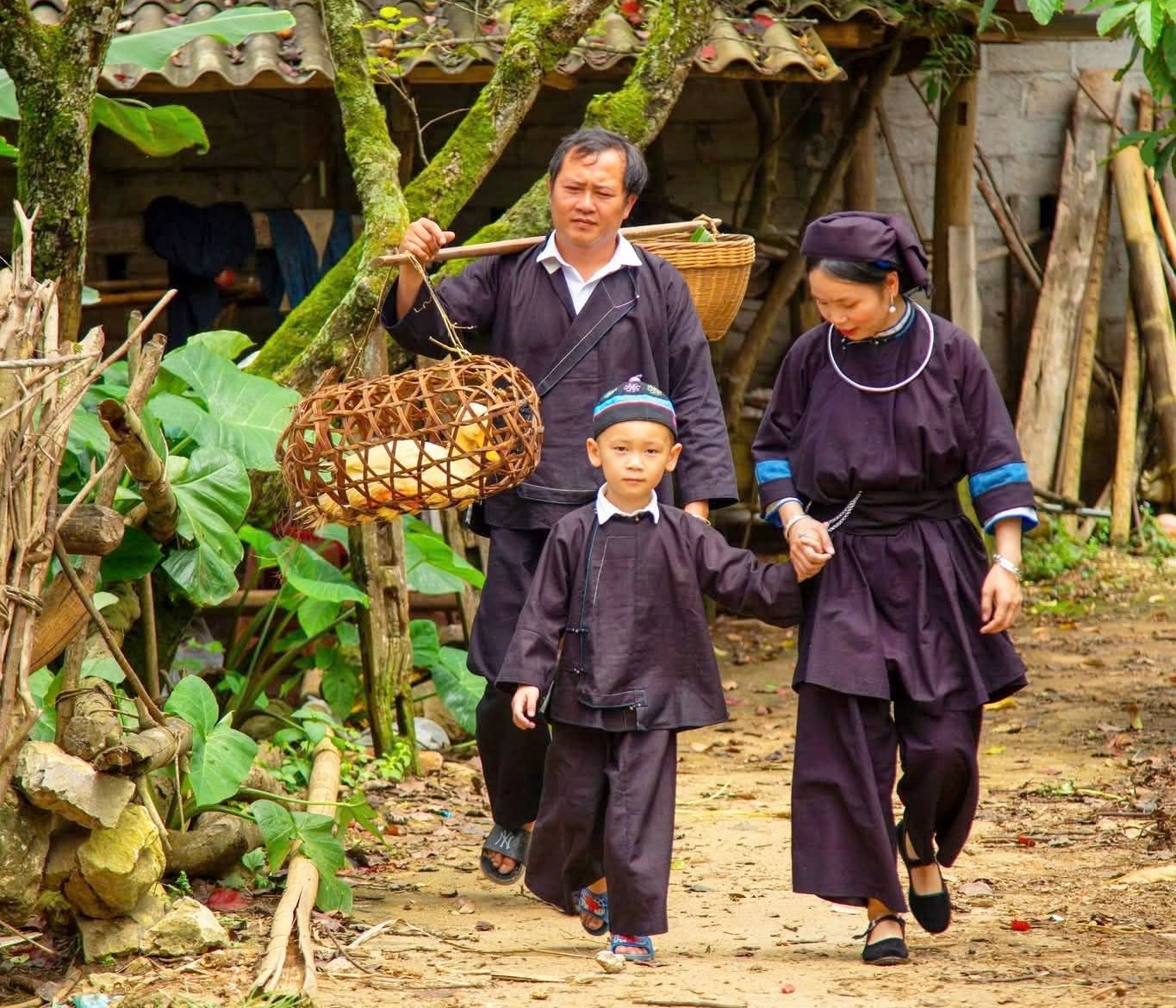 Cha mẹ dắt con, gùi vịt, mang bánh trên con đường quen thuộc về nhà ngoại.