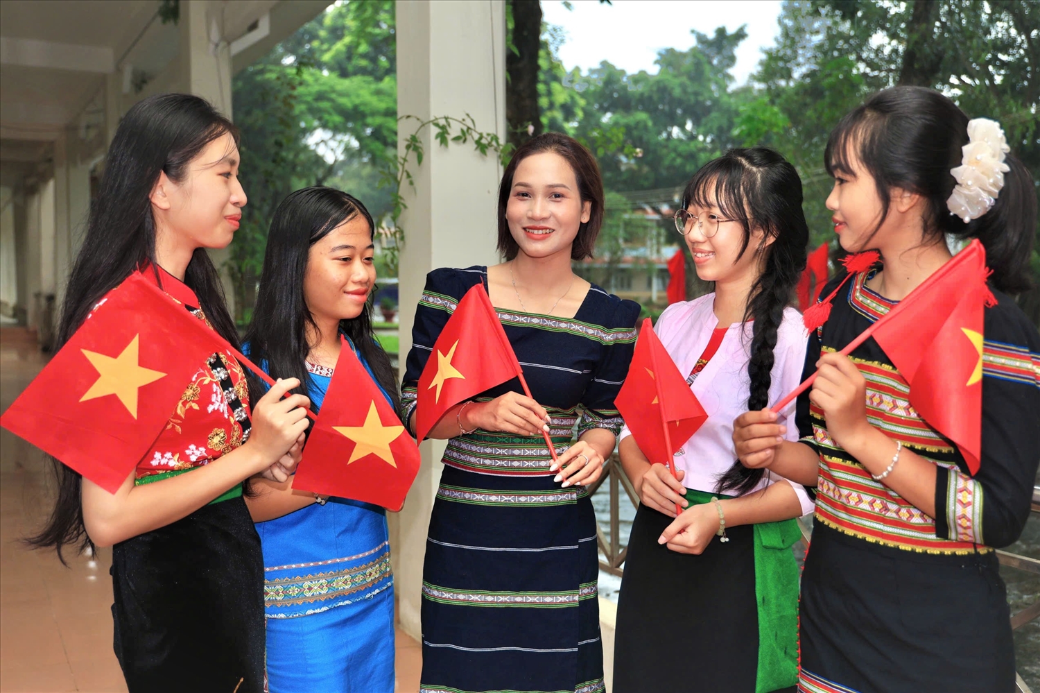 Cô giáo Nàng Xô Vi (đứng giữa), Trường PTDTNT THPT Kon Tum trò chuyện cùng các em học sinh trước khi vào Lễ khai giảng năm học mới. (Ảnh: Ngọc Chí)