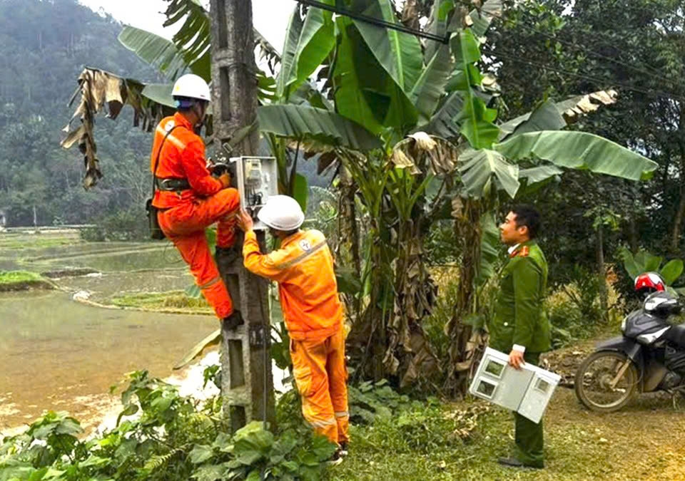 Điện lực khu vực Trấn Yên phối hợp chặt chẽ với lực lượng công an xã trong quá trình kéo điện cho các hộ dân (ảnh Trọng Bảo)