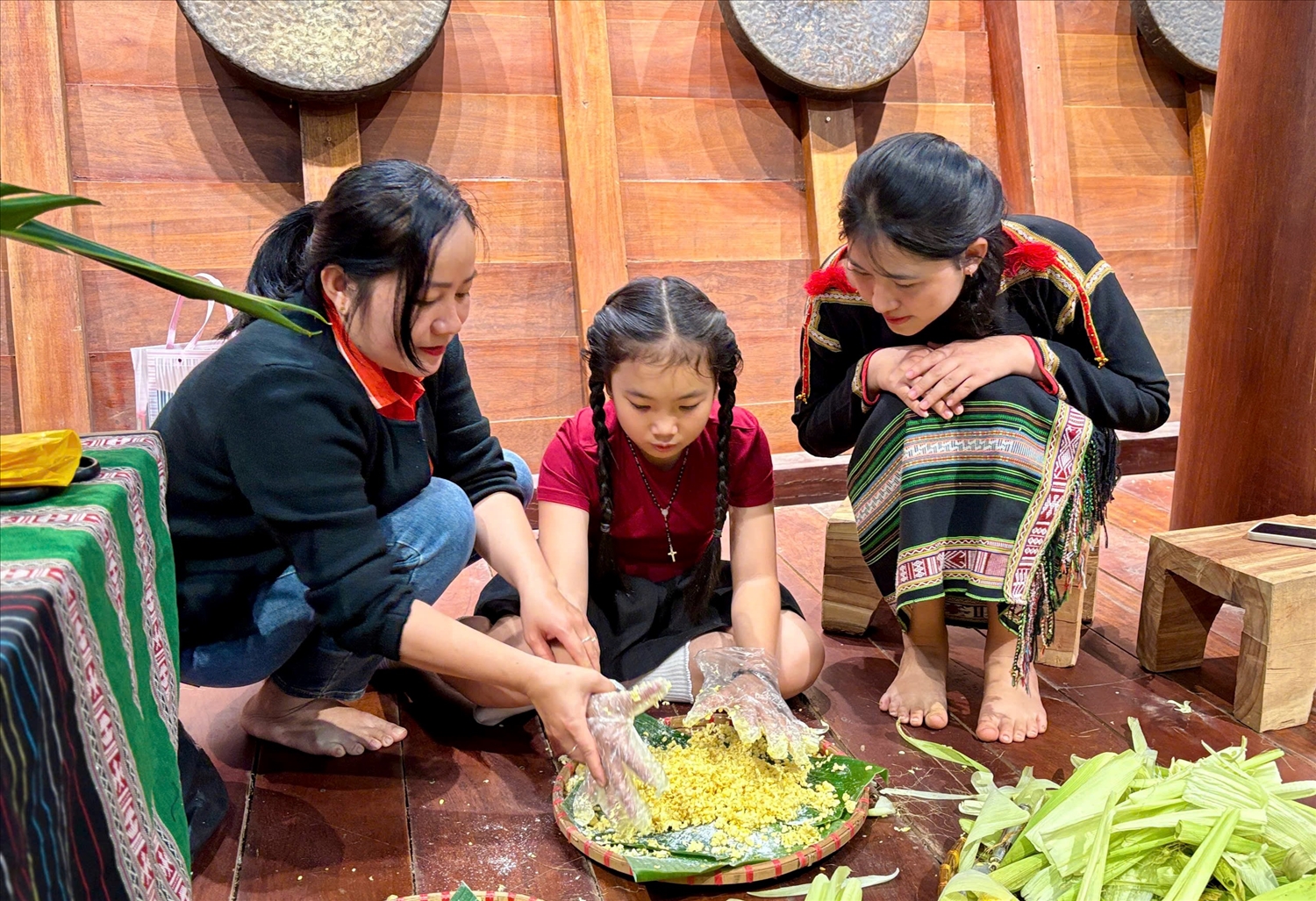 Du khách trải nghiệm làm bánh truyền thống của người Ê Đê tại nhà dài khuôn viên Bảo tàng Đắk Lắk