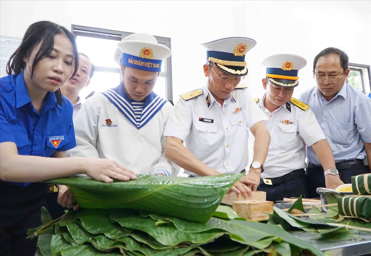 Chuẩn Đô đốc Ngô Văn Thành ( đứng giữa), Chính ủy Vùng 5 Hải quân, Trưởng đoàn công tác tham gia gói bánh chưng cùng sĩ và đại biểu đoàn công tác