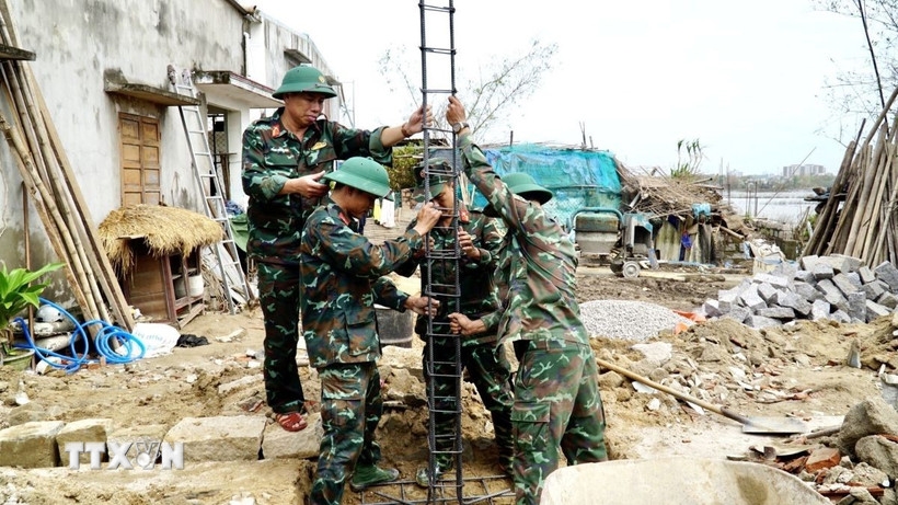 Lực lượng quân đội thực hiện xây nhà cho người dân vùng lũ ở Gia Lai (Ảnh: Sỹ Thắng/TTXVN)