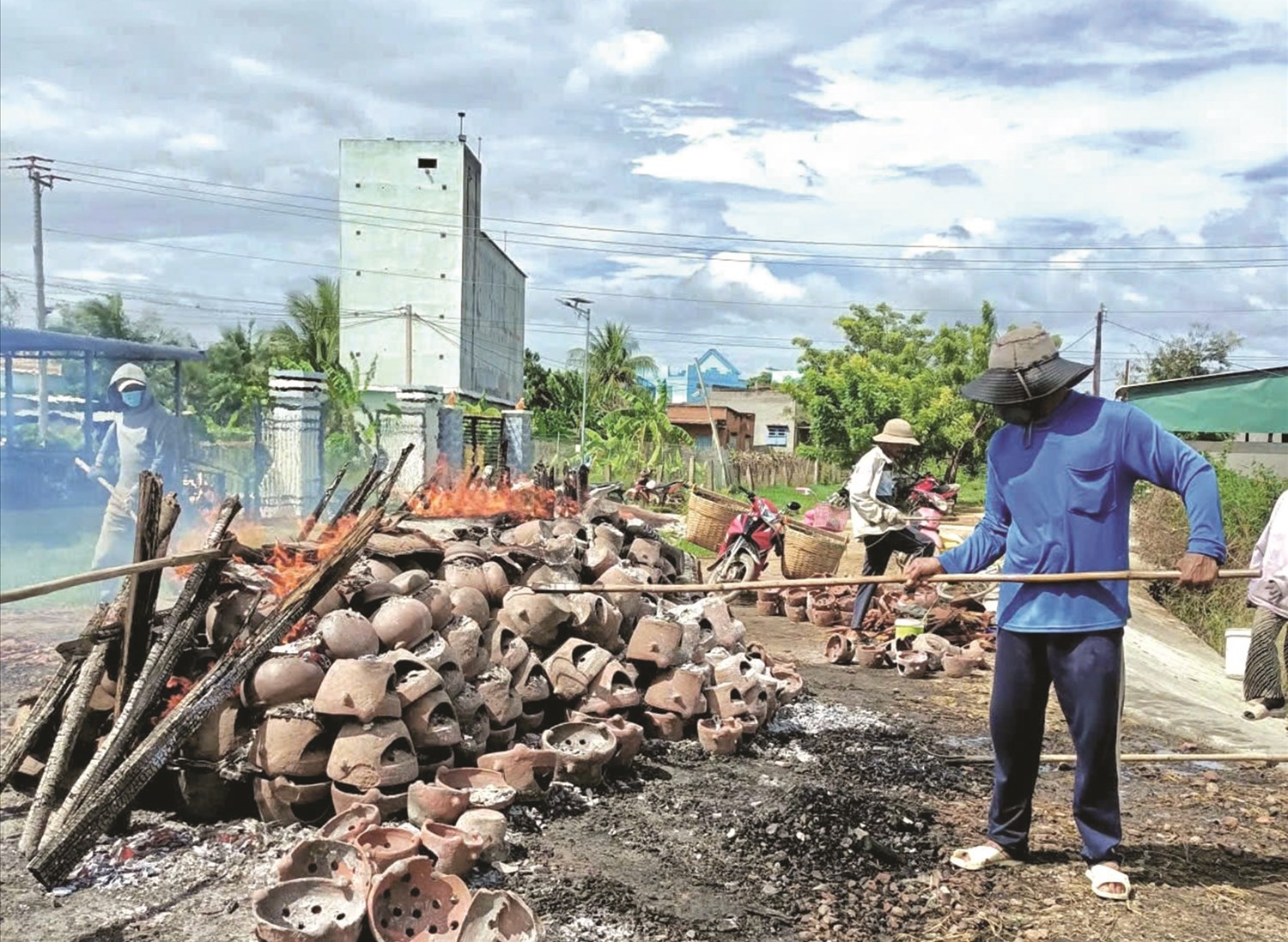 Công đoạn đưa sản phẩm gốm gọ đã nung đủ lửa ra ngoài
