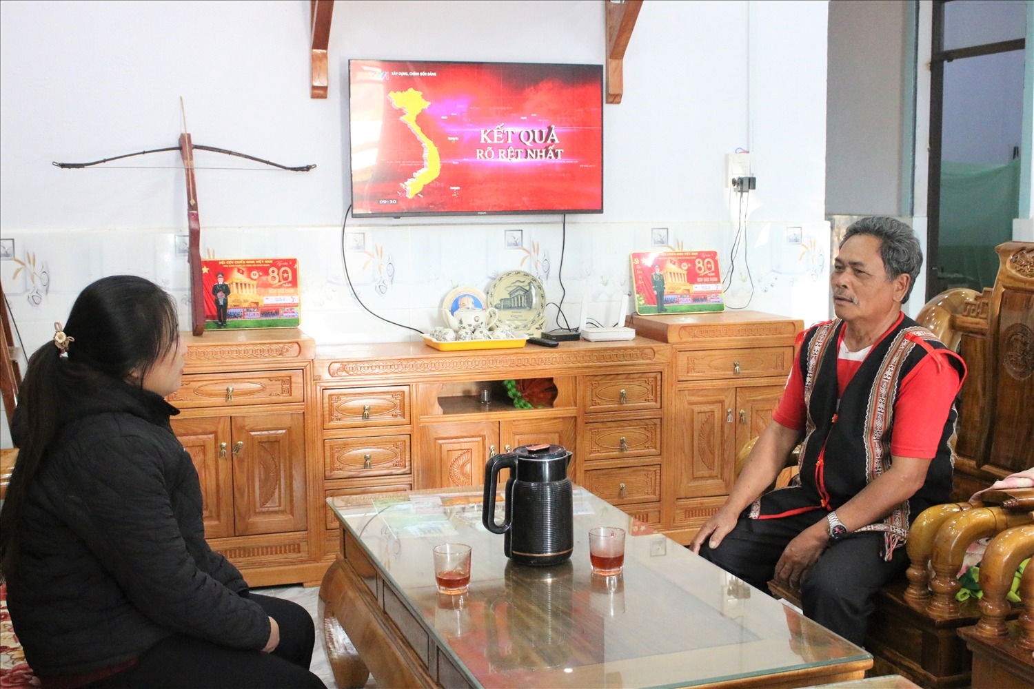 Nhờ trồng cây cà phê mà ông A Bu (áo thổ cẩm), thôn Broong Mỹ, xã Đăk Môn có thu nhập ổn định và xây dựng được nhà của khang trang. (Ảnh: Ngọc Chí)