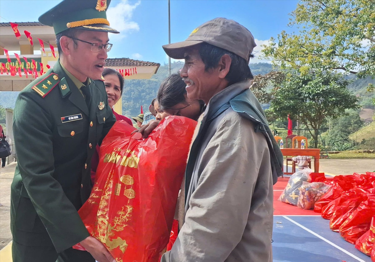 Trung tá Vũ Văn Trung - Chính trị viên Đồn Biên phòng A Vao trao quà cho đồng bào. (Ảnh: Phạm Tiến)