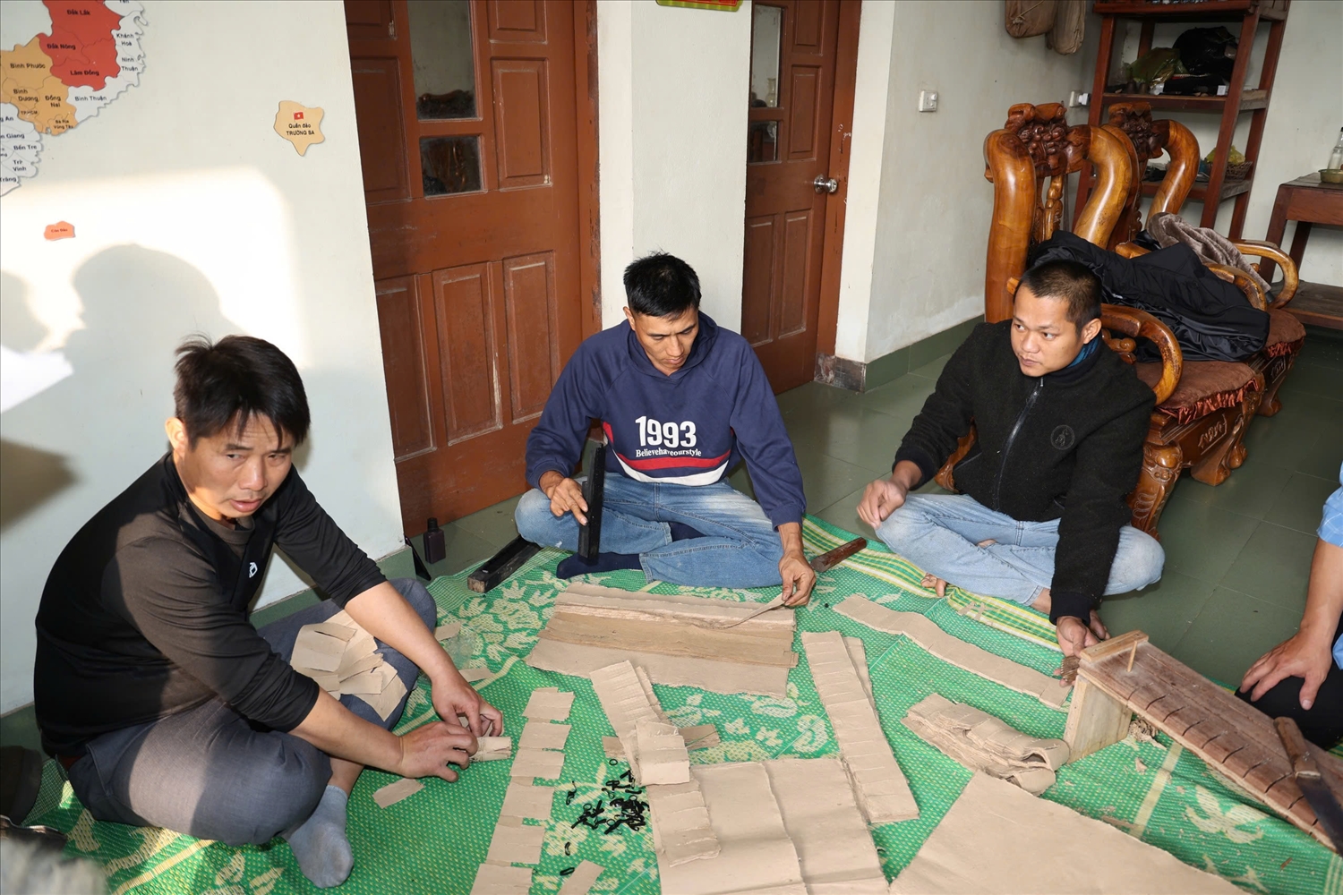 Thanh niên trẻ đang ngồi làm tiền giấy để chuẩn bị cho lễ cúng