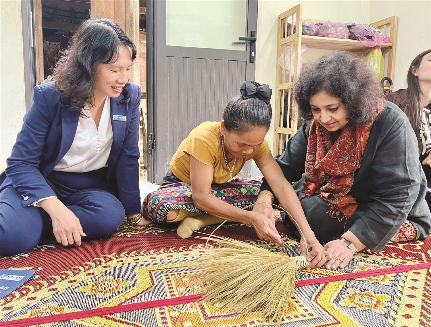 Chị Hồ Thị Lâng (người ở giữa), người Bru Vân Kiều ở Đakrông, tỉnh Quảng Trị tham gia dự án “Tiến về phía trước” của Plan International Việt Nam, được hỗ trợ học nghề làm chổi, có thêm thu nhập khoảng 1,8 triệu đồng/tháng. Ảnh: Plan International Việt Nam