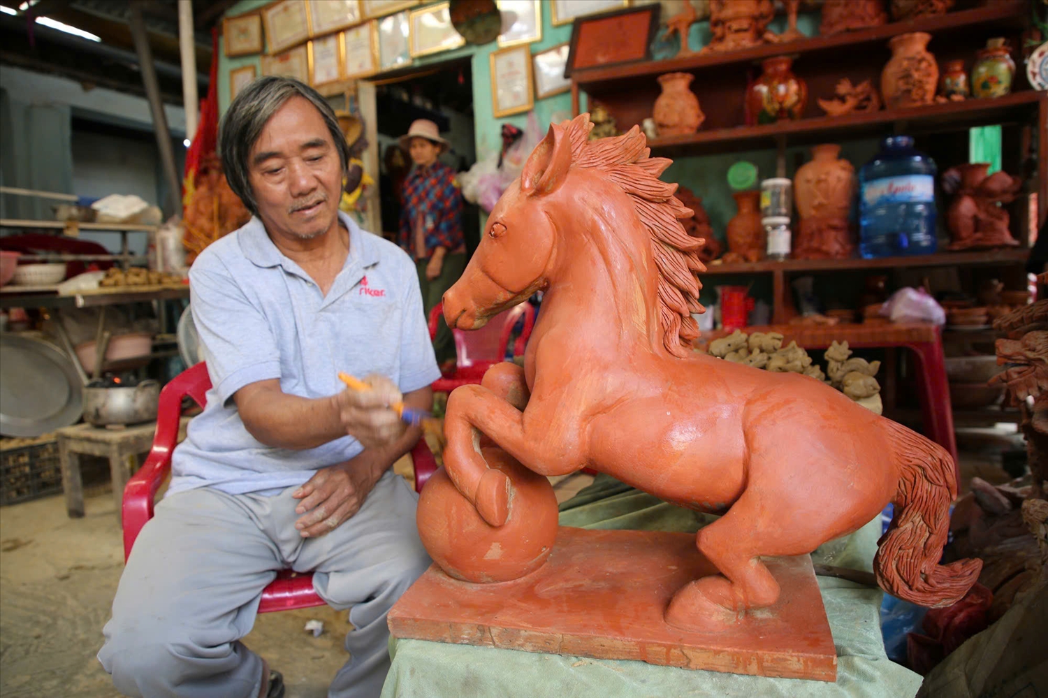 Nghệ nhân Lê Văn Xê đang hoàn chỉnh tác phẩm linh vật năm Bính Ngọ. (Ảnh NH)