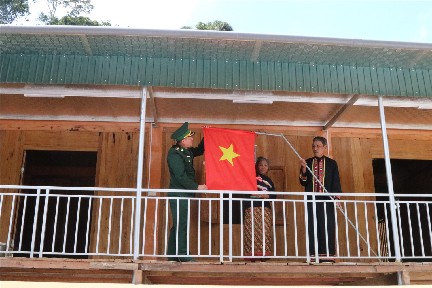 Người dân bàn Giàng II treo cờ Tổ quốc trong ngôi nhà mới