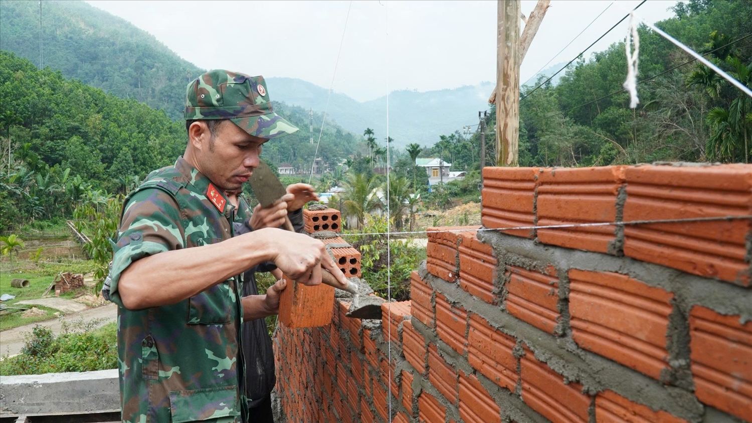 Mặc dù thời tiết không thuận lợi nhưng các chiến sĩ vẫn miệt mài xây nhà cho người dân với tinh thần hết việc không hết giờ. (Ảnh P.N)