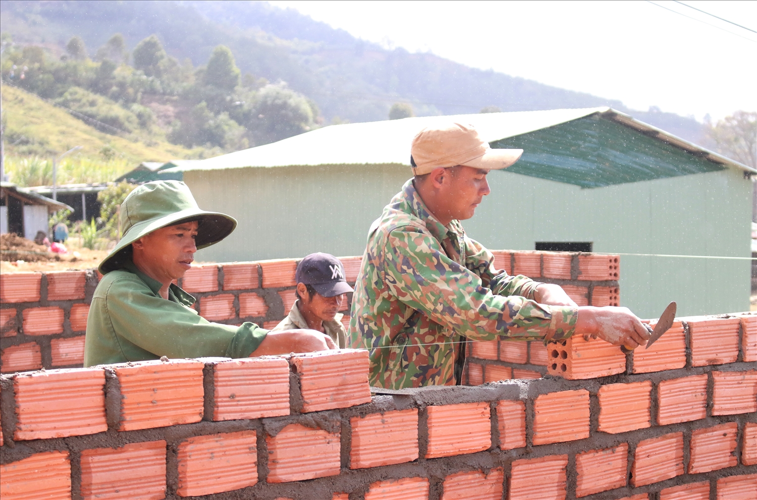 Những người thợ xây trong làng Chum Tam cùng giúp nhau xây dựng nhà. (Ảnh: Ngọc Chí)