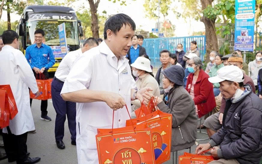 Lãnh đạo Bệnh viện Trung ương Huế trao quà cho bệnh nhân trước lúc lên xe về quê đón Tết (Ảnh: Quang Điền)