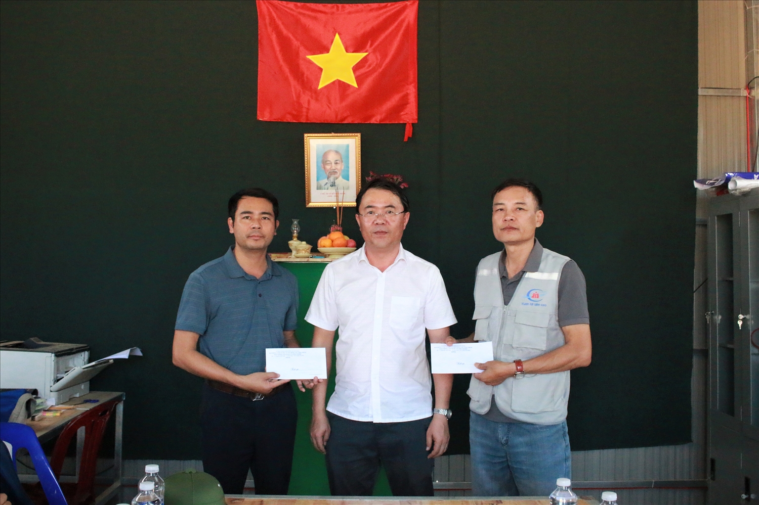 Ông Võ Đại Tân (đứng giữa), Giám đốc Ban Quản lý dự án đầu tư xây dựng các công trình giao thông, dân dụng và công nghiệp tỉnh Quảng Ngãi tặng quà, động viên 2 đơn vị bố trí công nhân làm việc xuyên Tết tại công trình Trường phổ thông nội trú liên cấp TH – THCS xã Mô Rai. (Ảnh: Ngọc Chí)