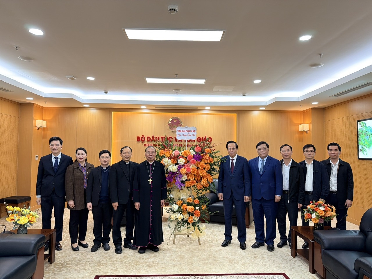 ổng Giám mục Tổng Giáo phận Hà Nội Giuse Vũ Văn Thiên tặng hoa chúc mừng, chụp ảnh lưu niệm với Bộ trưởng Đào Ngọc Dung và các đại biểu tại buổi tiếp. (Ảnh Mạnh Cường)