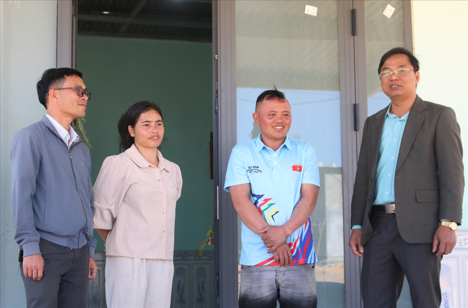 Anh A Cúc và vợ là Y Nghêu (đứng giữa), phấn khởi chuẩn bị đón Tết trong căn nhà mới tại điểm tái định cư thôn Kon Liêm, xã Xốp. (Ảnh: Ngọc Chí)