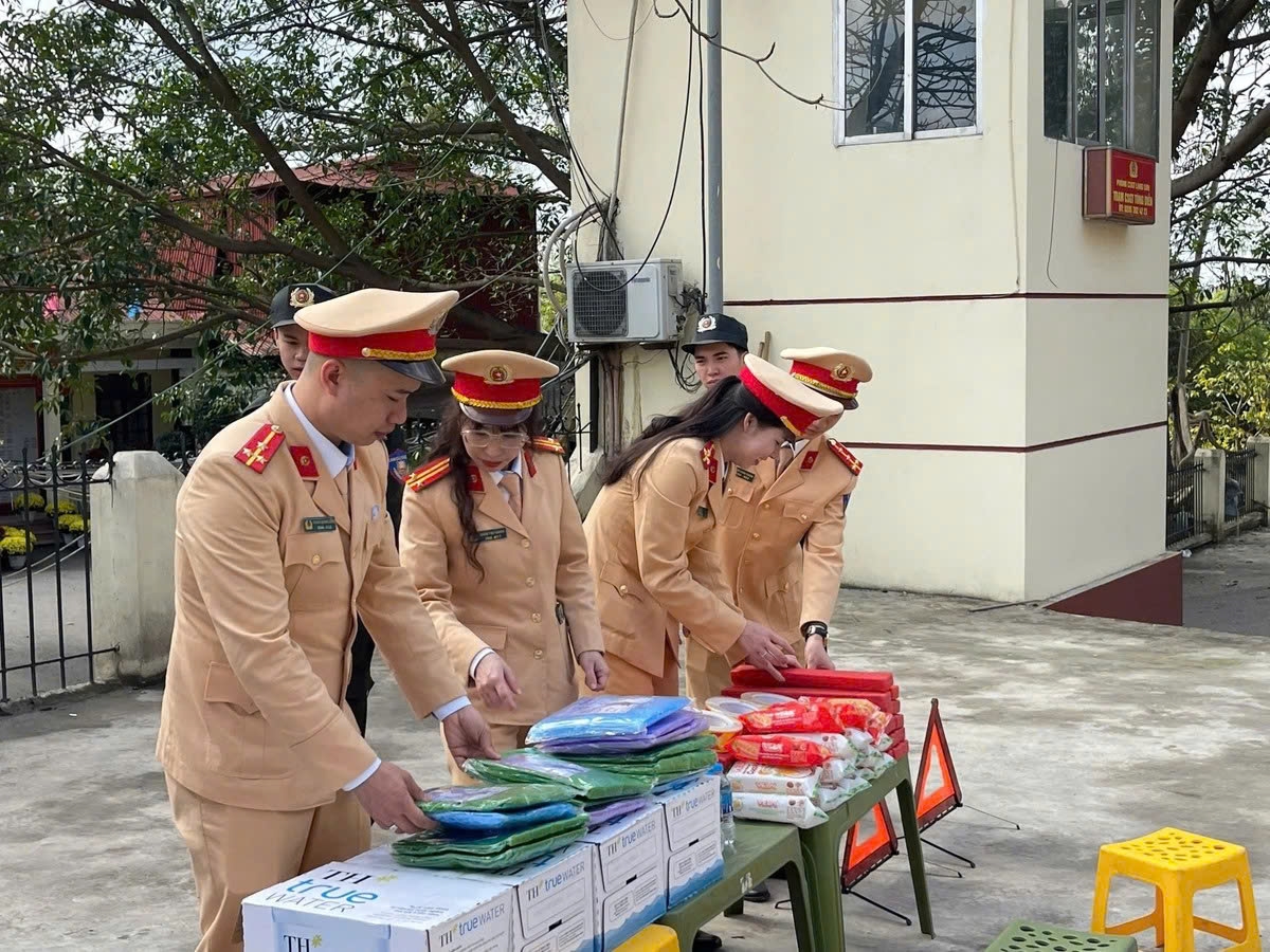 Cán bộ phòng CSGT, Công an tỉnh chuẩn bị nhu yếu phẩm để phát cho người dân tham gia giao thông trên tuyến Quốc lộ 1