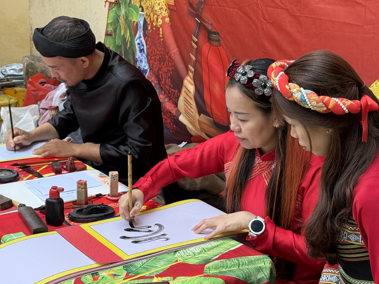 Không chỉ có hình ảnh ông đồ quen thuộc, những bà đồ xuất hiện với tà áo dài chỉn chu, duyên dáng